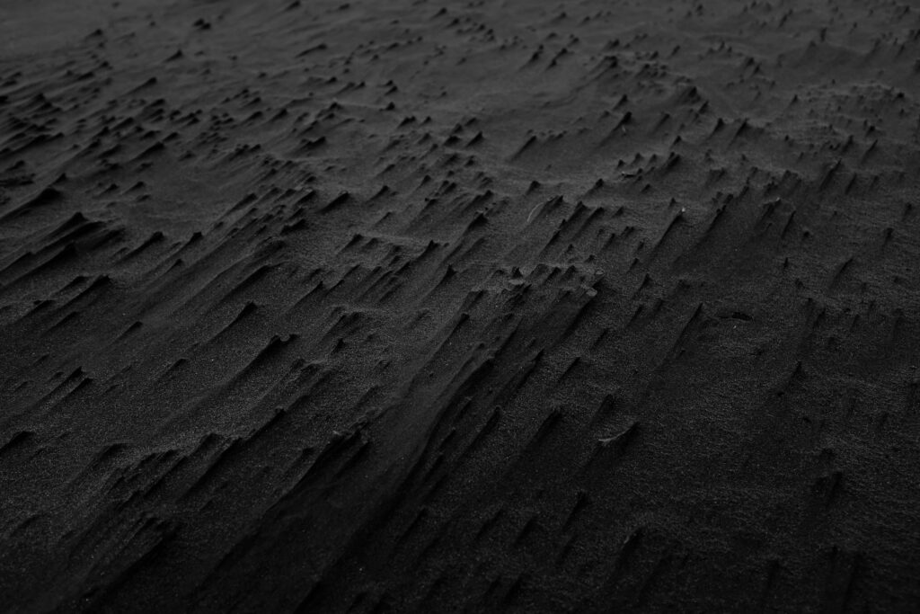 Abstract black sand texture creating a dramatic and moody background.
